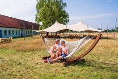 Hotelcamp Reinsehlen | Schneverdingen | Urlaubsgäste genießen ihr Eis in der Hängematte vor dem Freetent.
