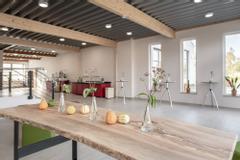 Hotelcamp Reinsehlen | Schneverdingen | roßes Foyer mit länglichem Stehtisch aus Holz, dekoriert mit Kürbissen