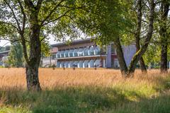 Hotelcamp Reinsehlen | Schneverdingen | Wiese mit Gräsern und Birken und Blick auf einen Zimmertrakt eines Hotels